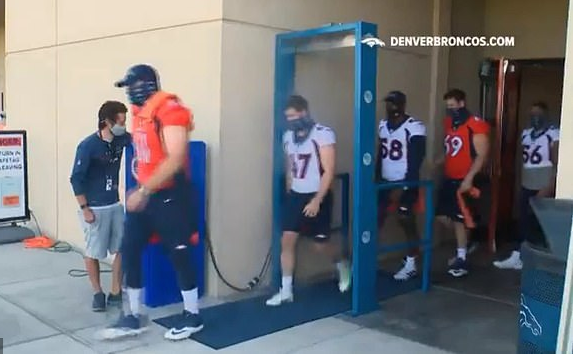 Image: Denver Broncos making football players walk through “disinfectant booth” before being allowed to play